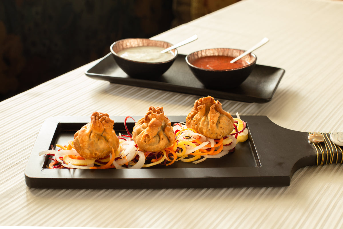 Pakora on the wooden board with chutneys